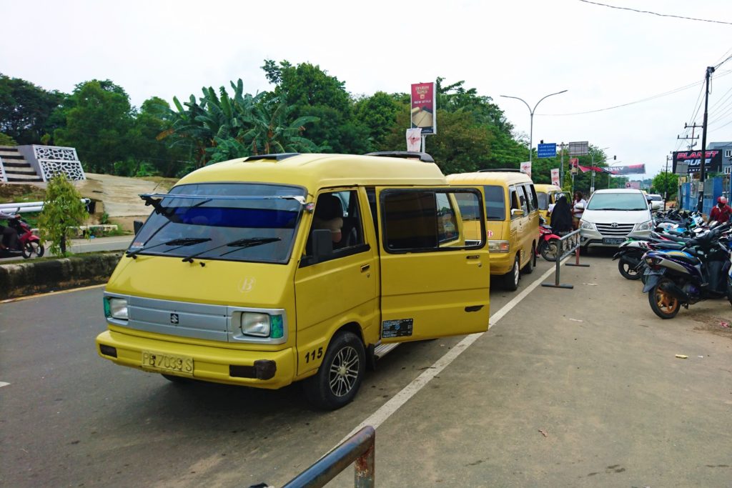 Yellow taxis "angkots" waiting on main road in Sorong