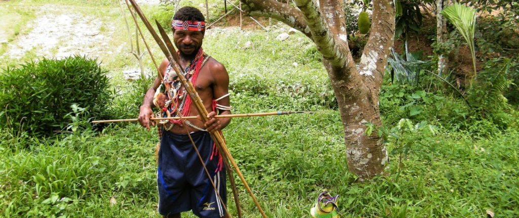 Head of the village poses with colorful necklaces and traditional spear