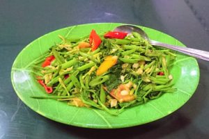 A plate of water spinach with papaya flowers