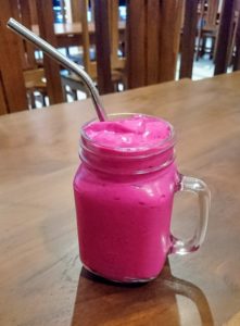 Glass of red dragonfruit smoothie on the table